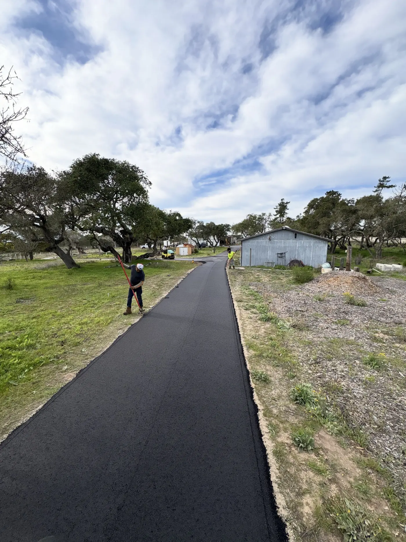 Walking down a freshly paved driveway under a bright sky